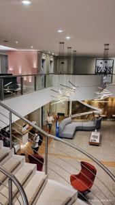 a lobby with a staircase with a couch and chairs at Flat Acolhedor e Familiar in Fortaleza