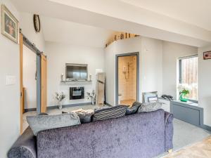 Una sala de estar con un sofá y un televisor. en Mayton Lodge, en Fordwich