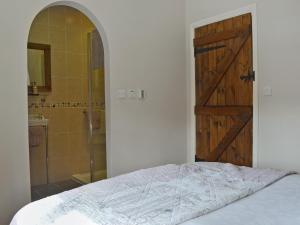 1 dormitorio con cama, puerta y ducha en Walkmill Lodge, en Wentnor