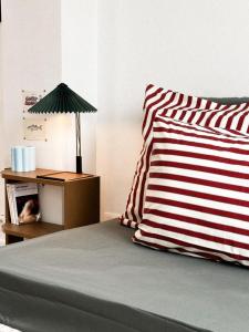 a bed with a red and white pillow and a lamp at Maison Lison - Gîte au Cap Gris Nez - Audinghen in Audinghen +28 photos