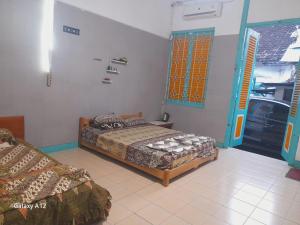 a bedroom with two beds and a kitchen at Ndalem Wongso in Yogyakarta +8 photos