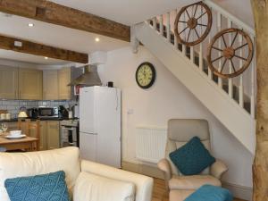 a kitchen and a living room with a white refrigerator at Cartwheel Cottage in Hawes