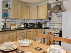 a kitchen with a wooden table with glasses on it at Cartwheel Cottage in Hawes