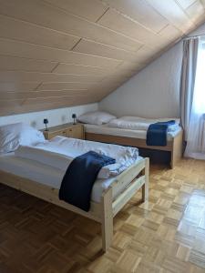Dos camas en una habitación con techo de madera. en Ferienwohnung Gerstetten 85 qm - 2 Schlafzimmer - Küche mit großem Essbereich - Wohnzimmer - Balkon - Bad - ruhige Lage, en Gerstetten