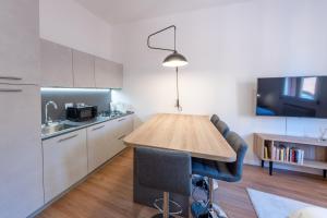 Una cocina con una mesa de madera en una habitación. en HouSmart Dimora D'Azeglio, en Bolonia