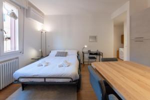 Un dormitorio con una cama y un escritorio. en HouSmart Dimora D'Azeglio, en Bolonia