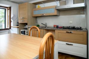 a kitchen with a wooden table and wooden cabinets at Romantic getaway on Lake Como in Brunate