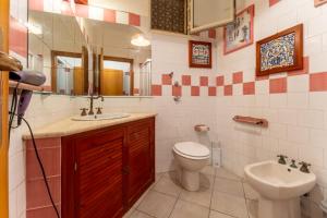 un bagno con lavandino, WC e specchio di Seavibe concept Marino in centro a Favignana