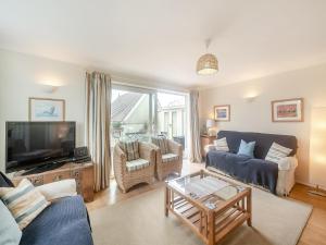 een woonkamer met een bank en een tv bij Stonehanger 2 - Cottage in Salcombe