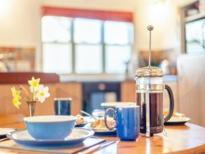 a table with plates and cups and a coffee maker at Hollow Creek Cottage - 28012 in Rockcliffe