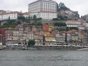 a group of buildings on a hill next to the water at Guest House Porto Clerigus in Porto