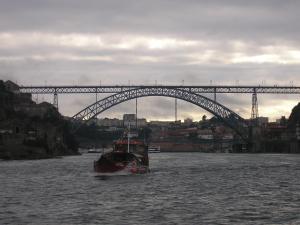 a boat in the water under a bridge at Guest House Porto Clerigus in Porto