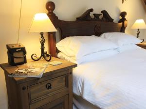 Bett mit Nachttisch mit Lampe in der Unterkunft Passion Flower Cottage - E1468 in Stowford + 11 Fotos