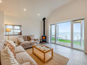 Una sala de estar con un sofá y una chimenea. en Y Beudy Gwydir, en Trevor