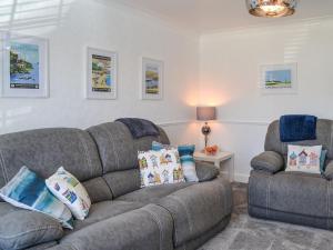 a living room with a couch and a chair at Beam Cottage in Flamborough