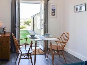 a table and chairs in a room with a window at Beam Cottage in Flamborough
