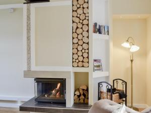 Una chimenea en una sala de estar con chimenea. en Jessamine Cottage, en Blairgowrie
