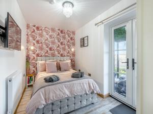 a bedroom with a large bed and a window at Rose Cottage in Peldon +9 photos