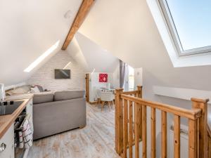 a living room with a couch and a staircase at Rose Cottage in Peldon