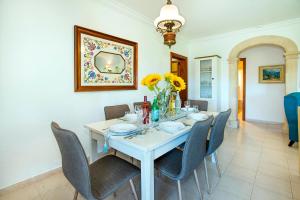 a dining room with a white table and chairs at Villa GERANIOS in El Port