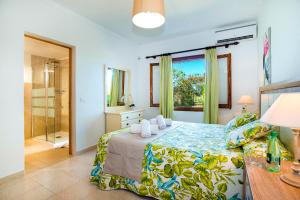a bedroom with a bed and a glass shower at Villa GERANIOS in El Port +14 photos