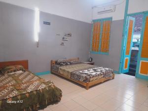a bedroom with two beds and a window at Ndalem Wongso in Yogyakarta