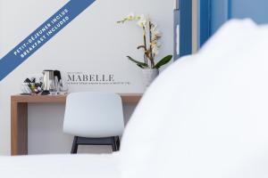 a white chair in front of a counter with a table at Hôtel Les Voiles in Toulon