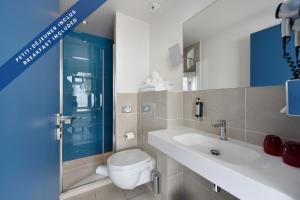 a bathroom with a toilet and a sink at Hôtel Les Voiles in Toulon