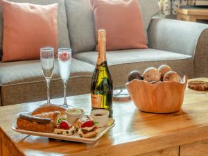 einen Tisch mit einer Flasche Champagner und einem Korb mit Speisen in der Unterkunft Nobles Cottage - Uk43351 in Whitby