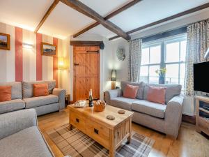 ein Wohnzimmer mit zwei Sofas und einem Couchtisch in der Unterkunft Nobles Cottage - Uk43351 in Whitby