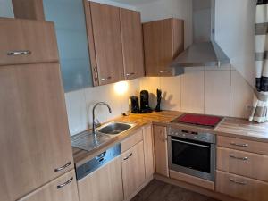 a kitchen with wooden cabinets and a sink and a stove at Apart im Tal in Oberried