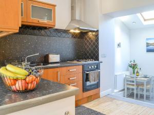 a kitchen with a bowl of fruit on a counter at Church View in Cockermouth