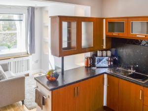 a kitchen with wooden cabinets and a counter top at Church View in Cockermouth +7 photos