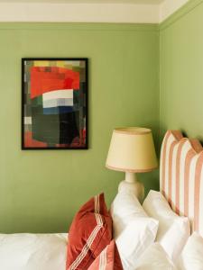 a bedroom with a bed with a lamp and a painting at The Pembroke Arms in Salisbury