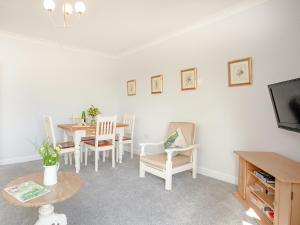 a living room with a table and chairs and a tv at Valley View - Uk43268 in Luppitt