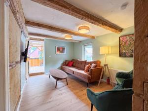 un salon avec un canapé et une table dans l'établissement Haus Ludwig - Saniertes Fachwerkhaus im Harz - 12 Personen, à Thale