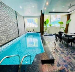Una piscina en una habitación con una mesa y sillas. en The Shore Travelista, en Rishīkesh