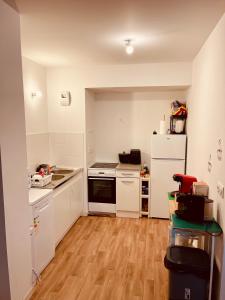una cucina con elettrodomestici bianchi e pavimento in legno di Location Appartement T3#1 a Pierrefitte-sur-Seine