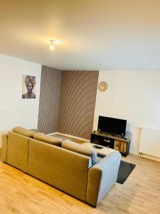 un soggiorno con un divano e una televisione di Location Appartement T3#1 a Pierrefitte-sur-Seine