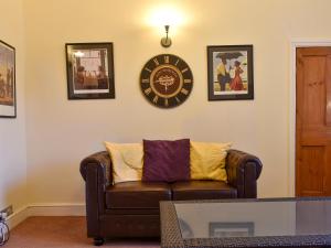 a living room with a couch and a clock on the wall at Idagale in Whitby