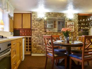 a kitchen with a wooden table with chairs and a tableasteryasteryasteryasteryastery at Idagale in Whitby