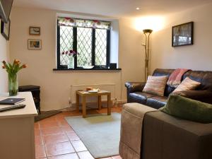 a living room with a couch and a table at Barn Court Cottage in Washfield
