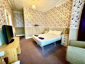 a bedroom with a bed and a tv in it at The Avon in Blackpool