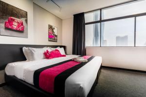 a bedroom with a bed with a red stuffed animal on it at MagTree Chinatown in Kuala Lumpur