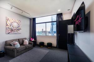 a living room with a couch and a large window at MagTree Chinatown in Kuala Lumpur