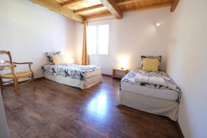 a room with two beds and a chair in it at nice villa with heated swimming pool, in the center of the village of aureille, 8 persons, near baux de provence, in the alpilles in Aureille +24 photos