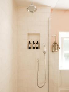 a shower with three bottles of wine in a bathroom at The Pembroke Arms in Salisbury