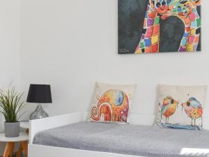 a bedroom with a bed with a painting on the wall at High Street Apartment in Kessingland