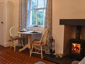 a living room with a table and a fireplace at Beeches in Windermere