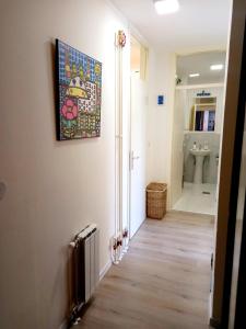 a hallway of a bathroom with a painting on the wall at Ena Apartment in Tuzla